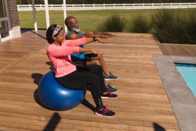 A Veteran and their partner, exercising in their backyard