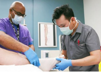 Two people examining a foot