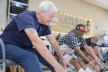 A group of older Veterans work out together in a class.