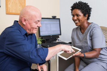 A patient and their health care provider in an exam room.