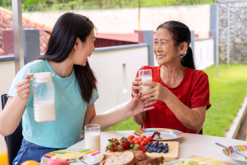 Two people drink milk during breakfast at home.