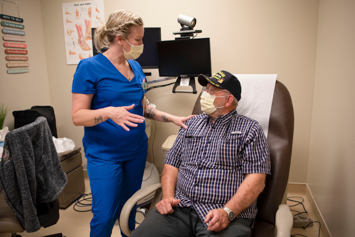Veteran in an exam room talking to a member of his primary care team 