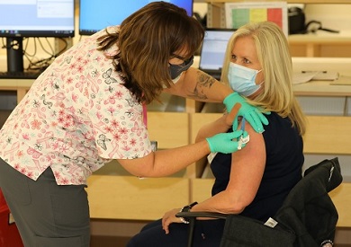 Someone receiving the COVID-19 vaccine from the SAVE LIVES Act