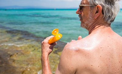 A Veteran applying sunscreen at the beach