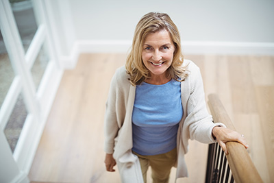 Senior woman climbing upstairs at home