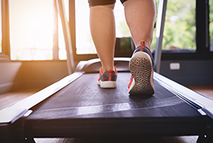 Young woman walking on treadmill