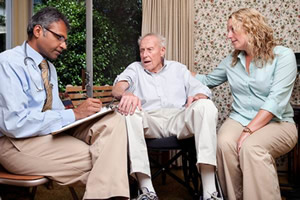 Photo showing a patient and his caregiver meeting with their Doctor
