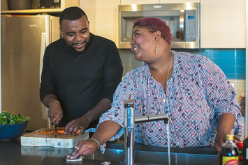 A Veteran couple preparing a meal together in their kitchen