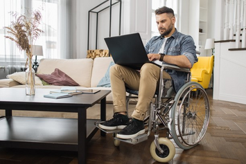 A Veteran in a wheelchair using My HealtheVet on their laptop