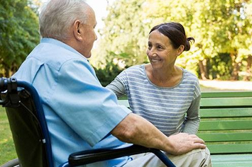 A Veteran couple sitting together at a park on a sunny day