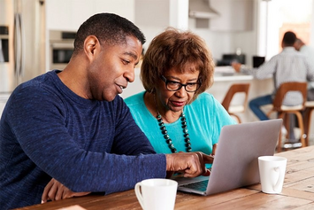 A family member showing a Veteran how to manage appointments online 