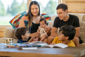 A Native Veteran and her partner spending time with their three children in their living room