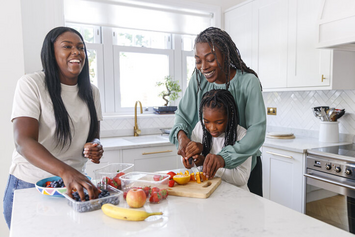 A Veteran family preparing a meal together in their kitchen 