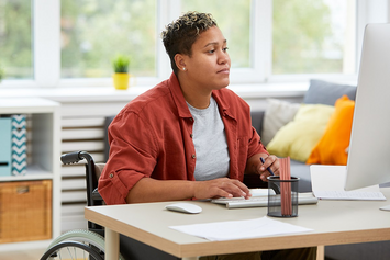 A Veteran at her computer desk sending a message to her health care team