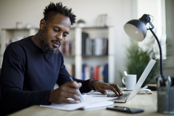 A Veteran at his laptop in his home sitting at a desk