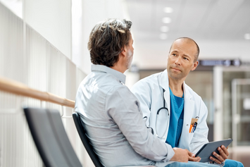 A Veteran sitting and talking to his health care provider at his local VA