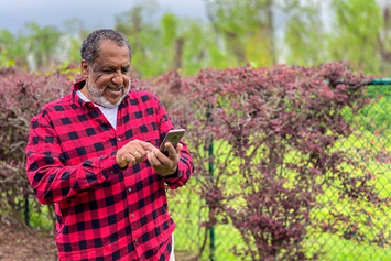A Veteran taking a walk and logging in to My HealtheVet on his phone to review his cholesterol levels