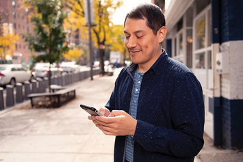 A Veteran checking his phone for VA text messages 